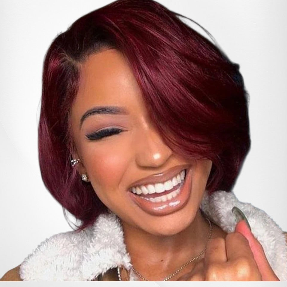 RitzWigs burgundy short bob human hair wig with side part and bangs worn by a smiling woman