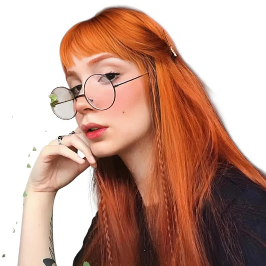 RitzWigs ginger long straight human hair wig with bangs worn by a woman with round glasses