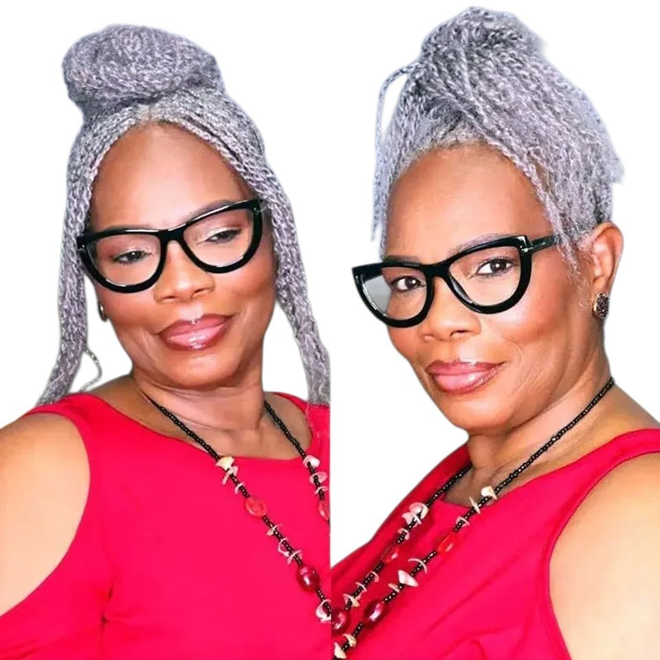 RitzWigs grey afro kinky human hair extensions styled in a high bun on a woman wearing a red top and black glasses