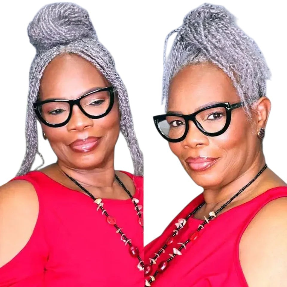RitzWigs grey afro kinky human hair styled in a high bun on a woman wearing black glasses and a red top