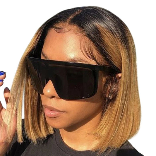 RitzWigs honey blonde straight bob lace front human hair wig with dark roots worn by a woman wearing large sunglasses