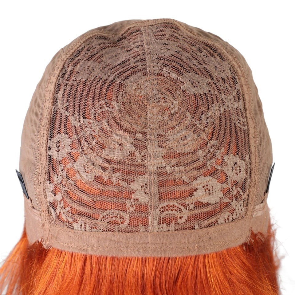 RitzWigs interior view of a machine-made wig cap with orange human hair strands and adjustable side clips.