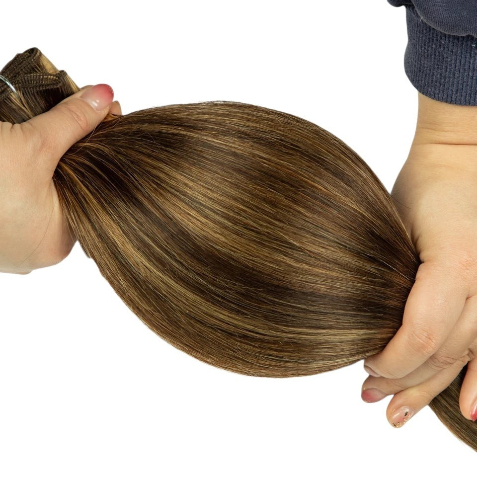 RitzWigs Peruvian straight human hair weave bundle with P4/27 brown and blonde highlights held in hands