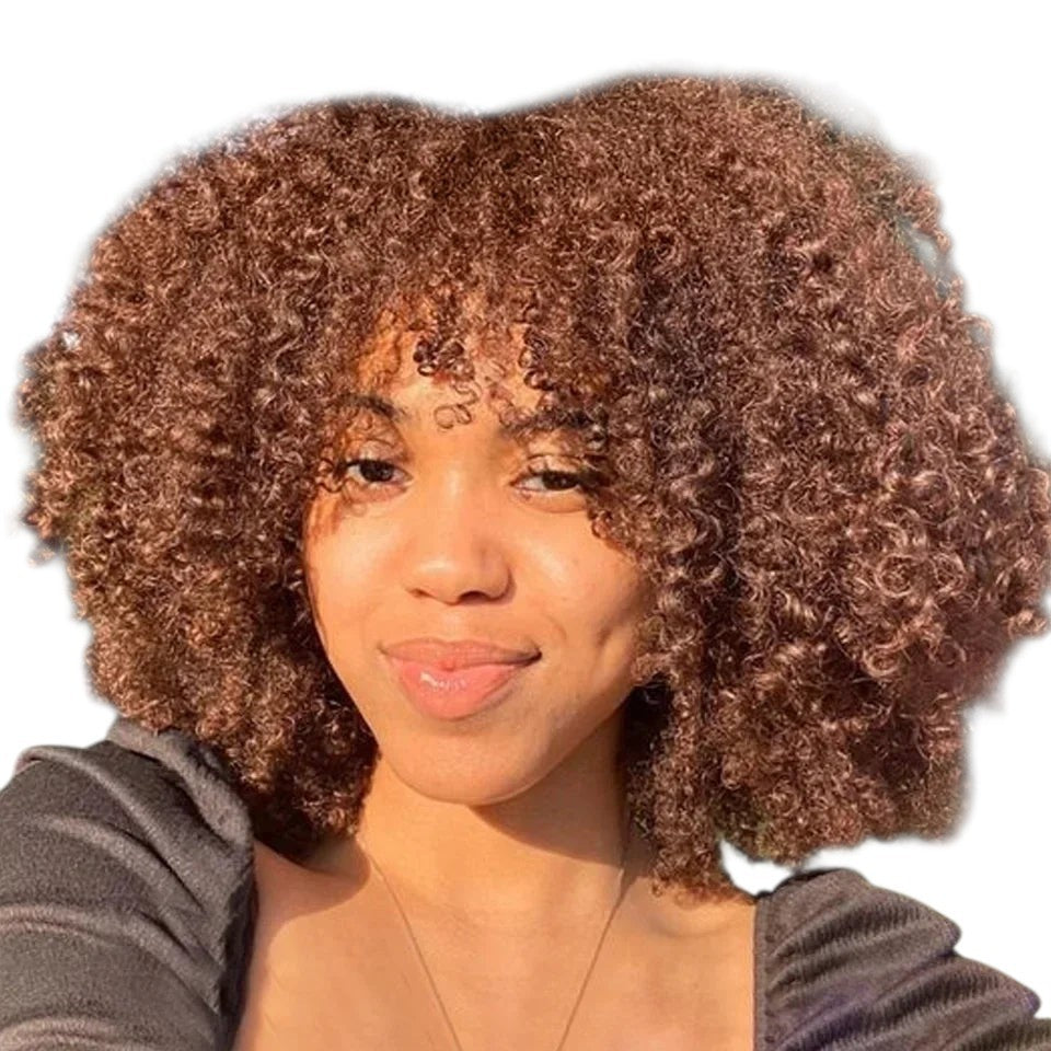 RitzWigs short kinky curly human hair wig with bangs on a model in a natural outdoor setting