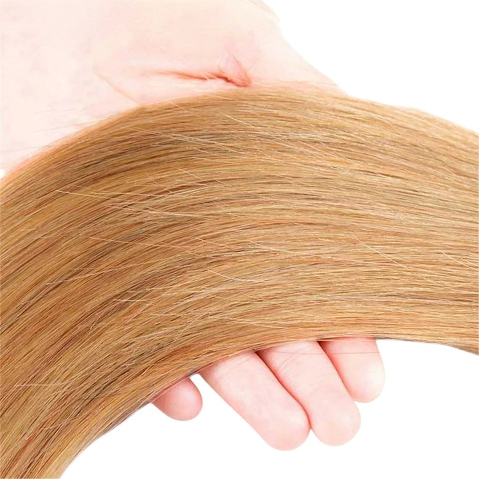 RitzWigs straight Brazilian Remy human hair extensions in a warm blonde colour held in a hand