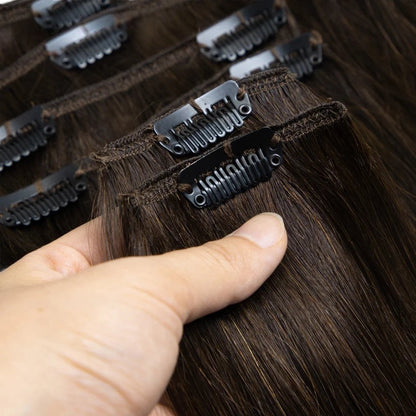 RitzWigs straight brown human hair clip-in extensions with secure metal clips held in a hand